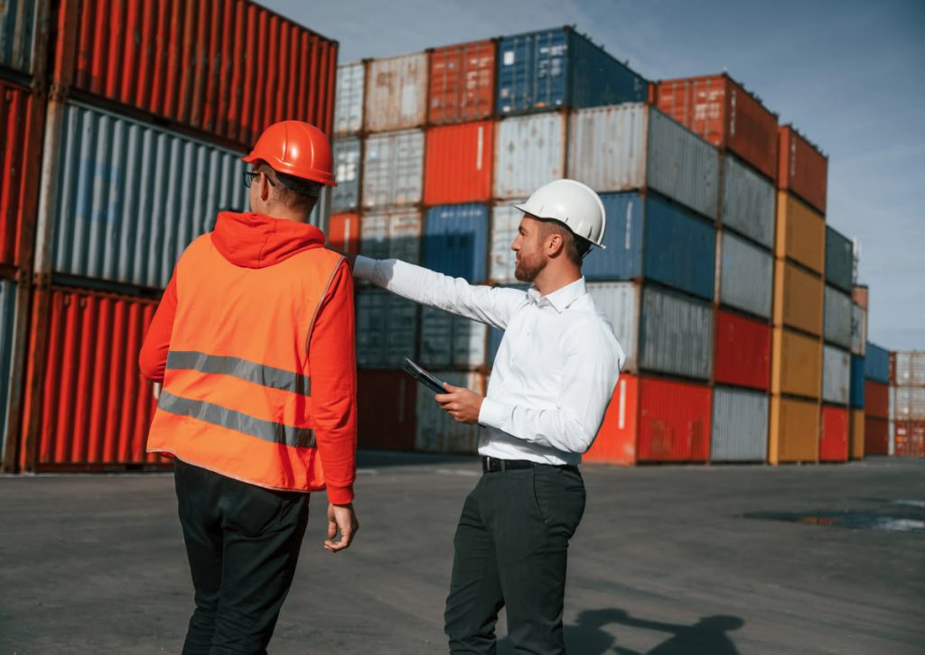 deux hommes devant des containers