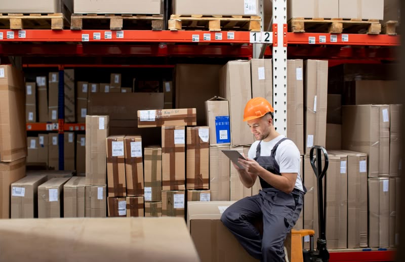 homme sur sa tablette dans un entrepot