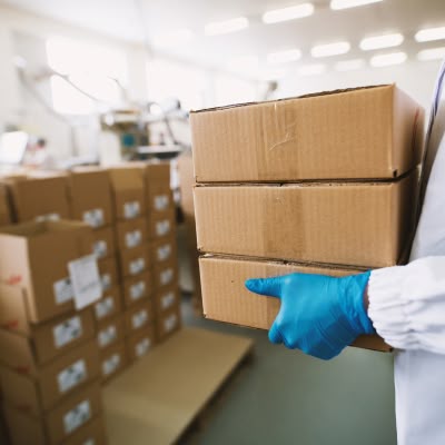 personne du médical qui porte des cartons